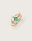 Yellow gold ring featuring an open kite-shaped diamond frame with a vivid round-cut emerald at the center.