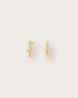 A pair of delicate yellow gold huggie earrings with pavé diamonds, accented by asymmetrical pear- and marquise-cut stones on a smooth, curved silhouette.