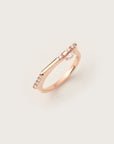 Rose gold ring with a minimalist band, featuring a marquise-cut diamond set sideways and accented by a row of delicate pavé diamonds.