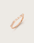 Slim rose gold ring featuring a linear row of baguette and round diamonds, creating a sleek, minimalist look against a light background.