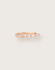 Sleek rose gold ring featuring a row of tapered baguette and round-cut diamonds.